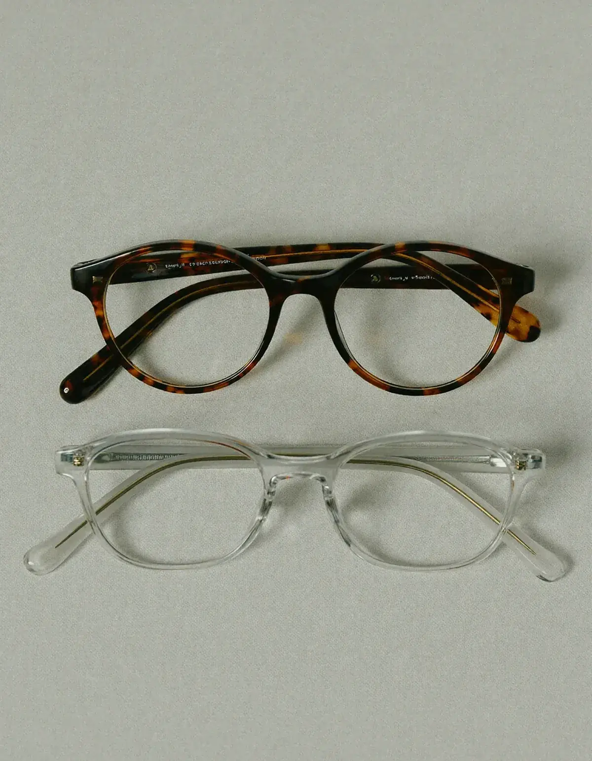 Two pairs of eyeglasses side by side, one round tortoiseshell and one rectangular clear-framed