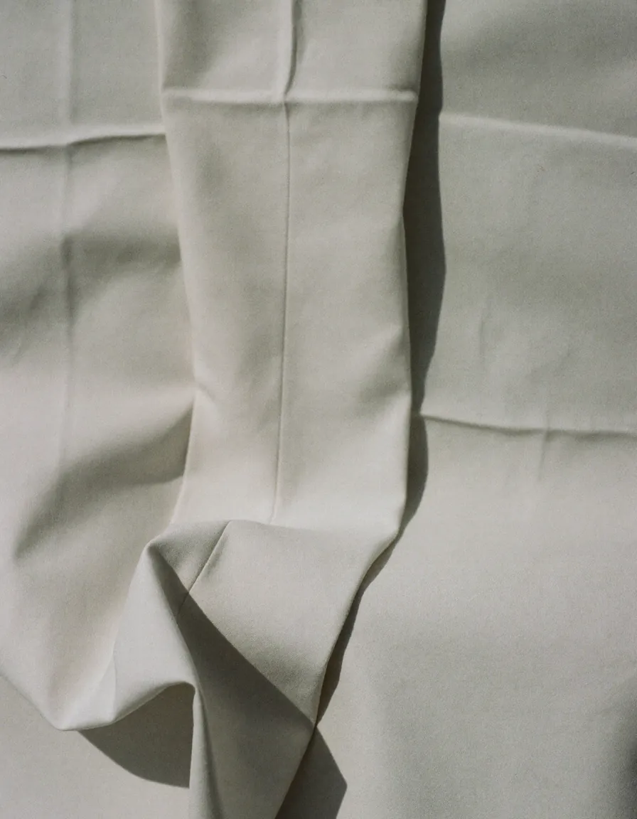 Soft ivory brushed cotton in gentle folds with one flat seam running through it